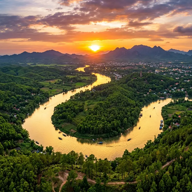 Toàn cảnh Đồi Vọng Cảnh nhìn từ trên cao, sông Hương uốn lượn phía dưới, ánh hoàng hôn nhuộm vàng mặt nước, rặng thông xanh bao quanh sườn đồi, khung cảnh hoàng hôn sông Hương Huế tuyệt đẹp