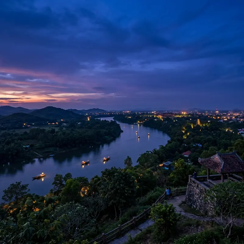Cảnh blue hour trên Đồi Vọng Cảnh sau hoàng hôn, bầu trời tím xanh huyền ảo, đèn thuyền le lói trên sông Hương, không khí tĩnh lặng và thơ mộng của Huế về đêm